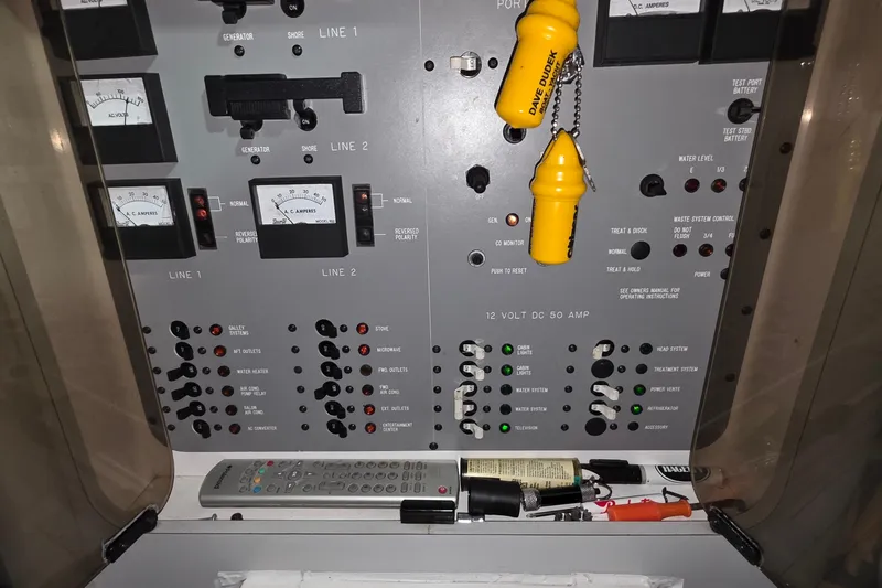 Slide: The Image of Electrical control panel of a 1989 Sea Ray 420 Sundancer boat with various switches and meters. - 42