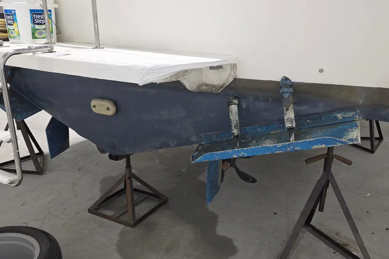 Slide: The Image of 1989 Sea Ray 420 Sundancer on stands, undergoing maintenance in a workshop. - 44