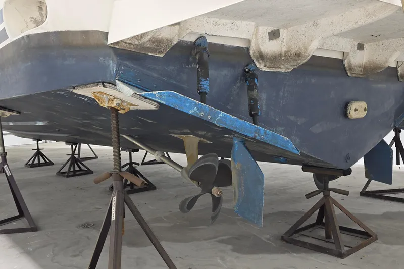 Slide: The Image of 1989 Sea Ray 420 Sundancer boat hull on stands, showcasing propeller and rudder. - 47