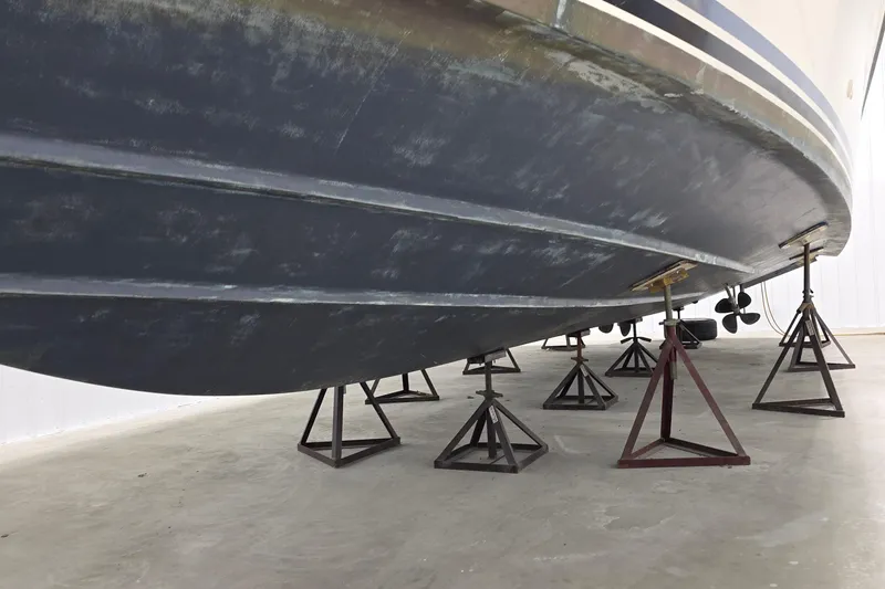 Slide: The Image of 1989 Sea Ray 420 Sundancer boat hull on stands in a storage facility. - 56