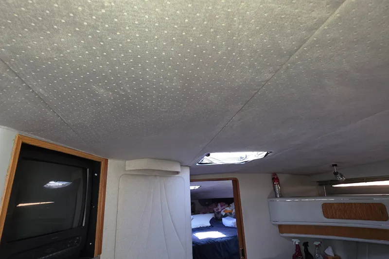 Slide: The Image of Interior of 1989 Sea Ray 420 Sundancer with TV, bed, and storage shelves. - 63