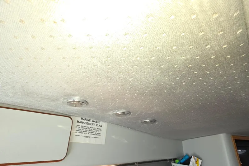 Slide: The Image of Interior ceiling of a 1989 Sea Ray 420 Sundancer with marine waste management plan notice. - 64