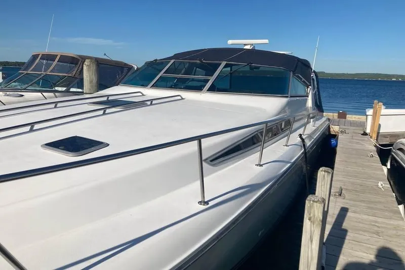 Slide: The Image of 1989 Sea Ray 420 Sundancer docked at a marina on a sunny day. - 7