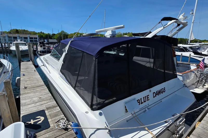 Slide: The Image of 1989 Sea Ray 420 Sundancer docked at marina with blue canopy. - 74
