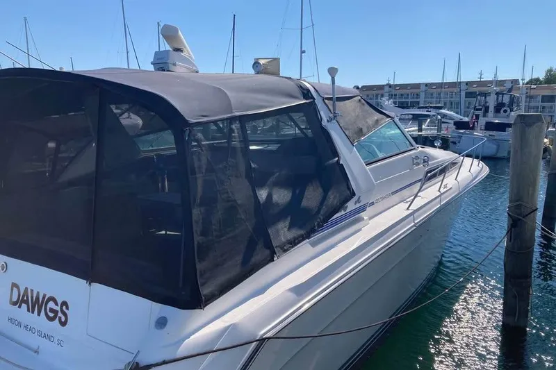 Slide: The Image of 1989 Sea Ray 420 Sundancer docked at marina, featuring black canopy and sleek design. - 8