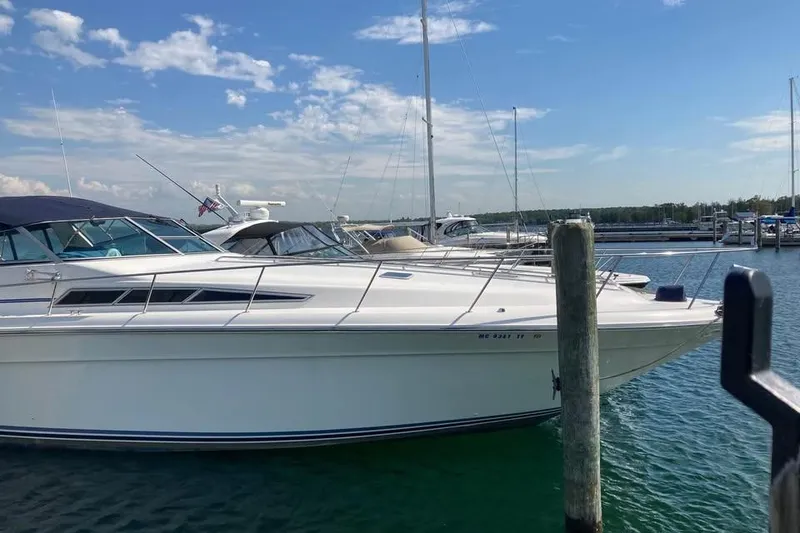 Slide: The Image of 1989 Sea Ray 420 Sundancer yacht docked in a marina under a clear blue sky. - 9
