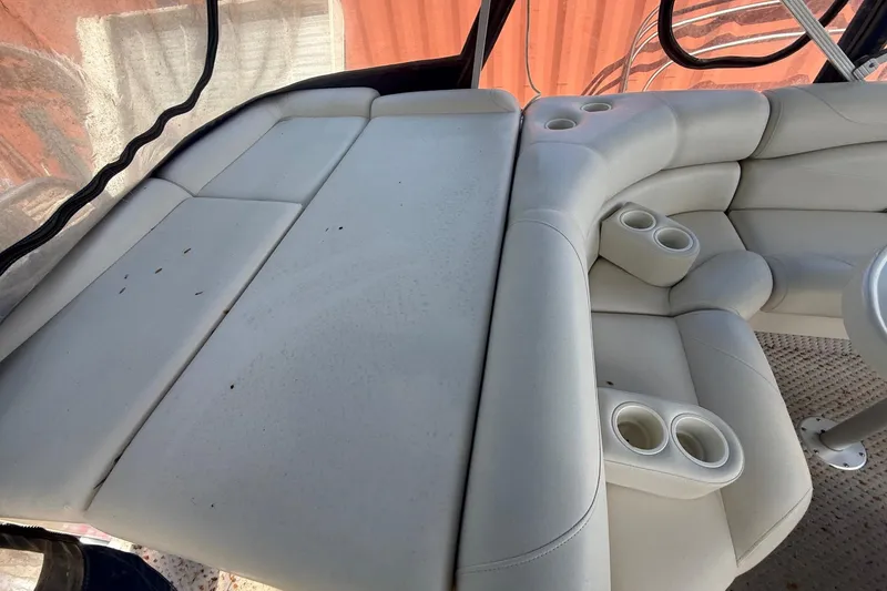 Slide: The Image of 2005 Bennington 2575RL boat interior with white cushioned seating and cup holders. - 10