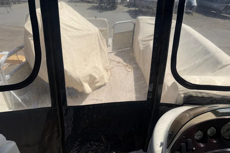 Slide: The Image of 2005 Bennington 2575RL boat interior with covered seating and dashboard view. - 12