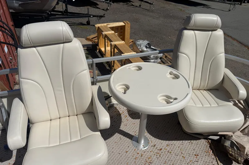 Slide: The Image of Two white boat seats with a round table on a 2005 Bennington 2575RL. - 15
