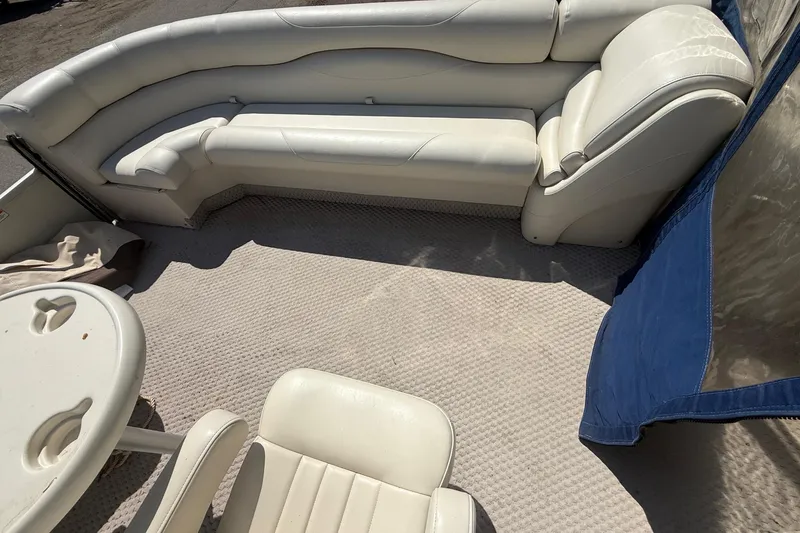 Slide: The Image of 2005 Bennington 2575RL boat interior with white seating and table. - 18