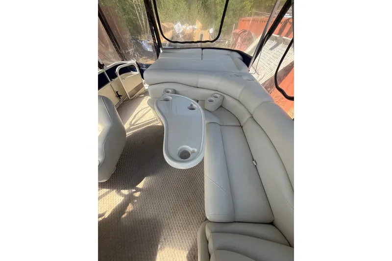 Slide: The Image of 2005 Bennington 2575RL boat interior with beige seating and cup holders. - 21