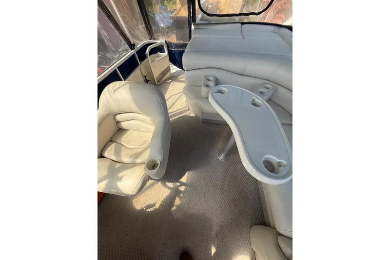 Slide: The Image of Interior of a 2005 Bennington 2575RL boat with beige seating and cup holders. - 23