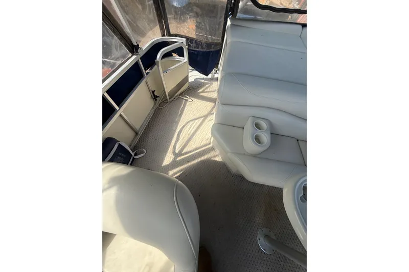 Slide: The Image of Interior of a 2005 Bennington 2575RL boat with white seating and cup holders. - 24
