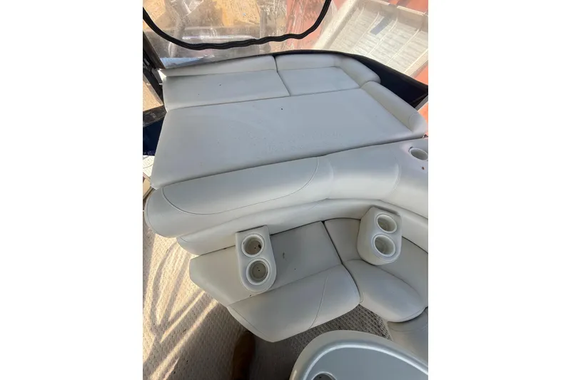 Slide: The Image of 2005 Bennington 2575RL boat interior with white cushioned seating and cup holders. - 25