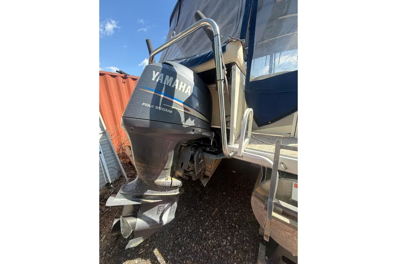 Slide: The Image of 2005 Bennington 2575RL boat with Yamaha four-stroke outboard motor, docked outdoors. - 6