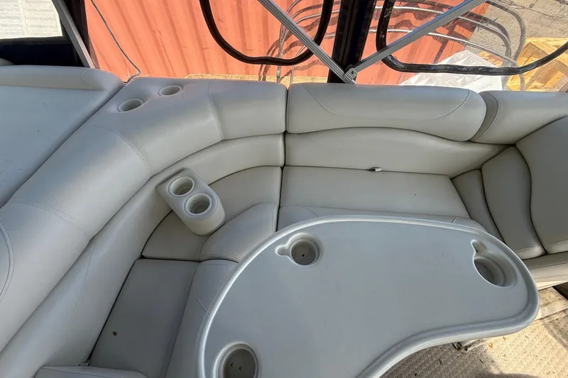 Slide: The Image of 2005 Bennington 2575RL boat interior with white cushioned seating and cup holders. - 9