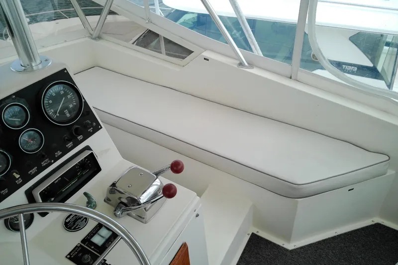 Slide: The Image of 1986 Viking 44 Motor Yacht helm with gauges, controls, and cushioned seating. - 10