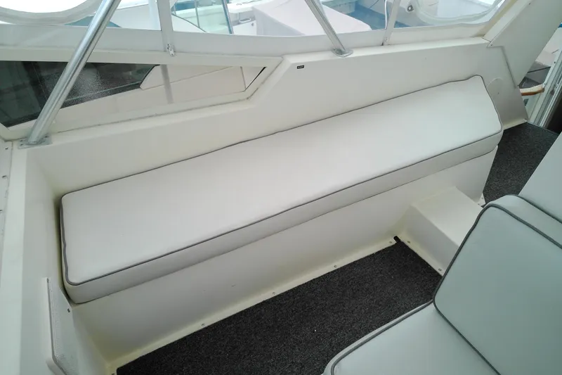 Slide: The Image of Interior seating of 1986 Viking 44 Motor Yacht with white cushions and carpeted floor. - 17