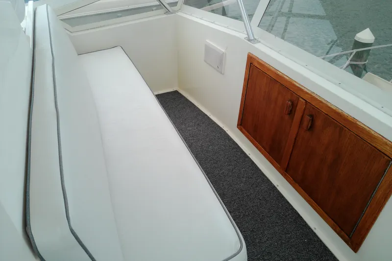 Slide: The Image of White seating area and wooden cabinet on 1986 Viking 44 Motor Yacht. - 18