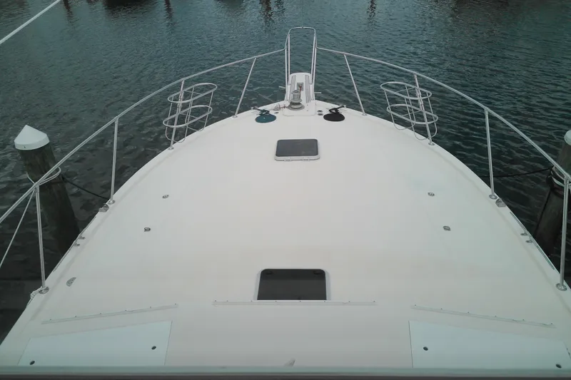 Slide: The Image of 1986 Viking 44 Motor Yacht bow view at marina, showcasing deck and railings. - 20