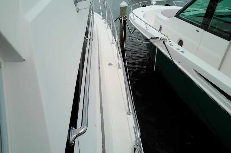 Slide: The Image of 1986 Viking 44 Motor Yacht docked beside another boat, showcasing sleek design and railing details. - 21