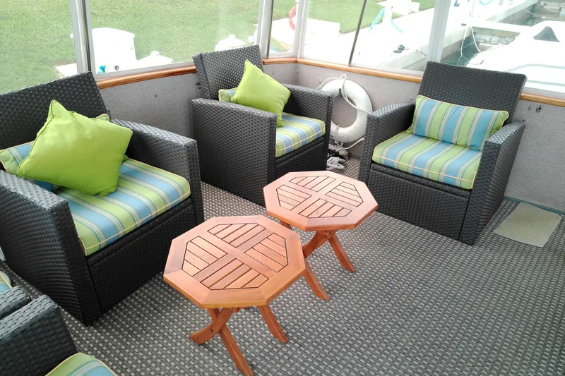 Slide: The Image of Cozy seating area on 1986 Viking 44 Motor Yacht with wicker chairs and wooden tables. - 3
