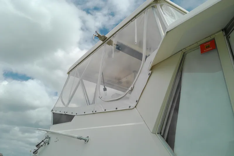 Slide: The Image of 1986 Viking 44 Motor Yacht with clear enclosure against cloudy sky. - 34