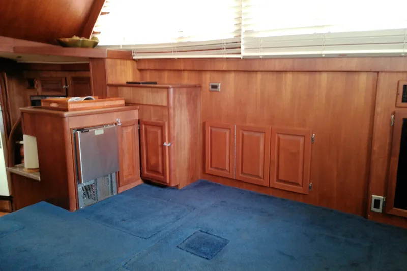 Slide: The Image of Interior of 1986 Viking 44 Motor Yacht with wood paneling and blue carpet. - 38