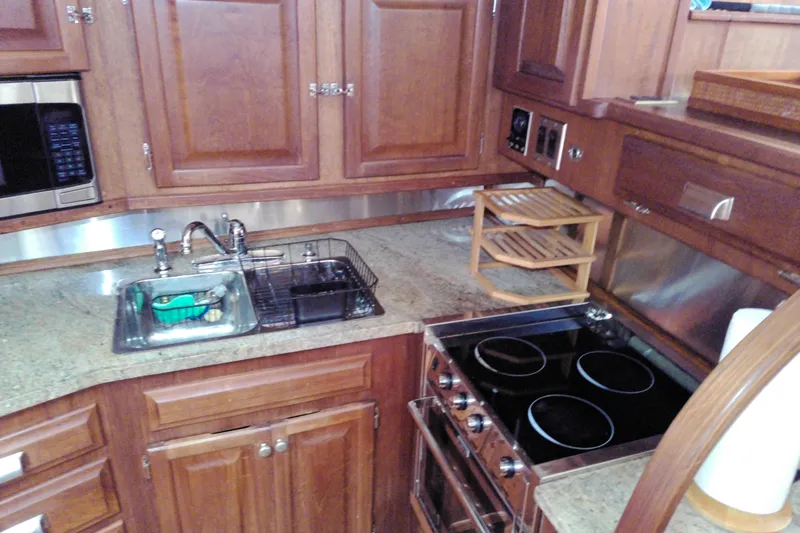 Slide: The Image of 1986 Viking 44 Motor Yacht kitchen with wooden cabinets, stove, and sink. - 41