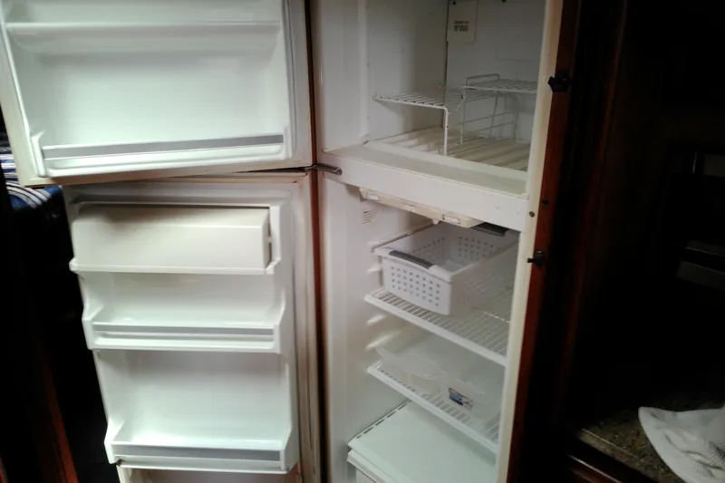 Slide: The Image of Empty refrigerator inside a 1986 Viking 44 Motor Yacht, featuring multiple shelves and door compartments. - 44