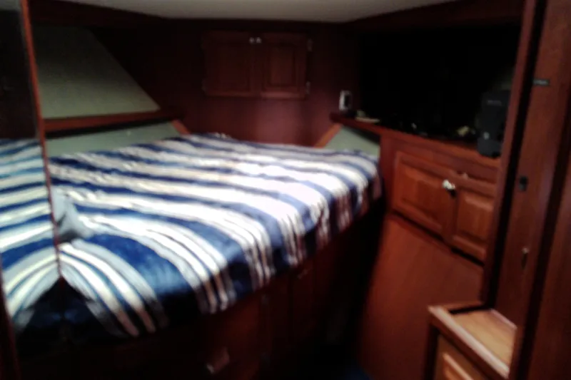 Slide: The Image of Cozy cabin interior of 1986 Viking 44 Motor Yacht with striped bedding. - 48