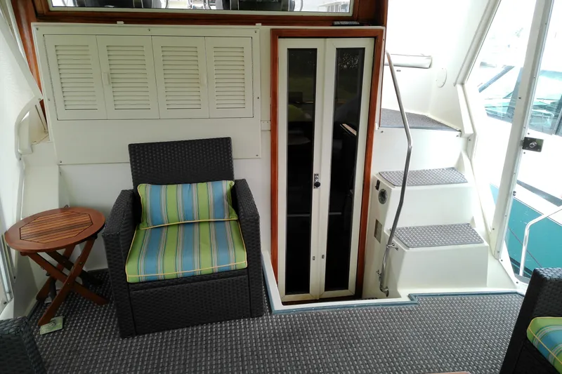 Slide: The Image of 1986 Viking 44 Motor Yacht interior with wicker chair, striped cushion, and stairs. - 5