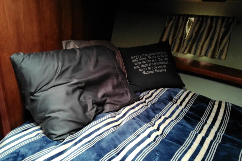 Slide: The Image of Cozy cabin bed in 1986 Viking 44 Motor Yacht with striped bedding and decorative pillows. - 50