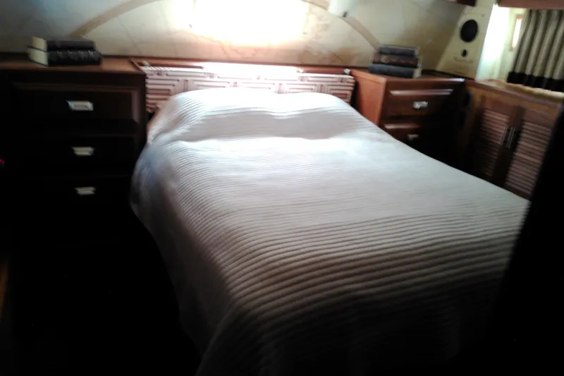 Slide: The Image of Cozy bedroom interior of 1986 Viking 44 Motor Yacht with wooden cabinets and soft lighting. - 56