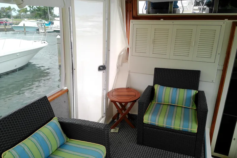 Slide: The Image of Cozy seating area on 1986 Viking 44 Motor Yacht with striped cushions and marina view. - 6