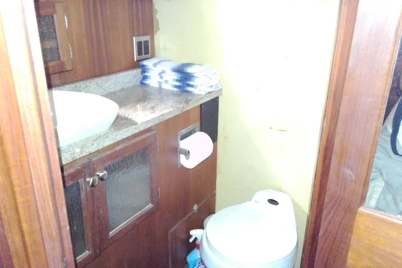 Slide: The Image of Bathroom interior of 1986 Viking 44 Motor Yacht with sink, toilet, and wooden cabinetry. - 61