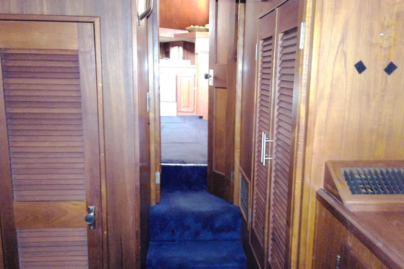 Slide: The Image of Interior of 1986 Viking 44 Motor Yacht with wooden cabinetry and blue carpeted steps. - 64