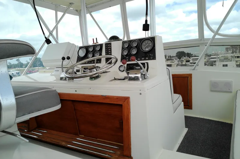 Slide: The Image of 1986 Viking 44 Motor Yacht helm with steering wheel, gauges, and controls. - 9