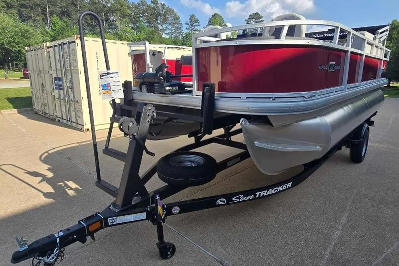 The Image of 2026 Sun Tracker Bass Buggy 18 DLX pontoon boat on trailer, parked outdoors. - 0