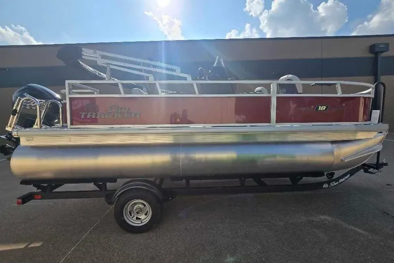 Slide: The Image of 2026 Sun Tracker Bass Buggy 18 DLX pontoon boat on trailer, outdoors. - 7
