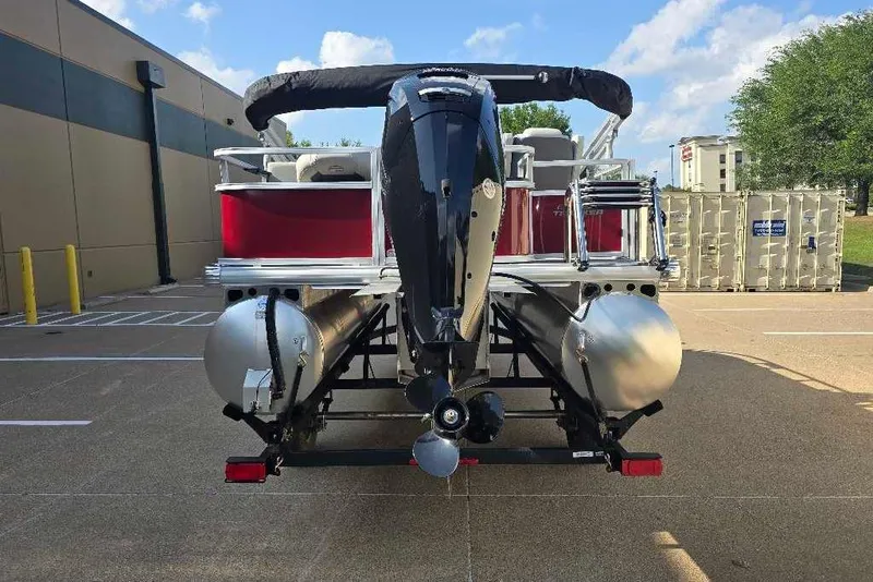 Slide: The Image of 2026 Sun Tracker Bass Buggy 18 DLX pontoon boat, rear view, parked outdoors. - 9