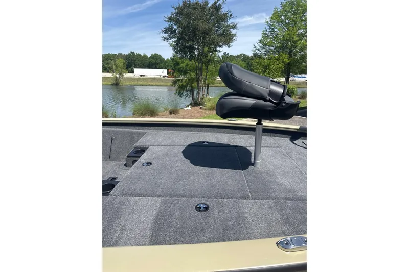 Slide: The Image of 2026 Tracker Pro Team 190 boat deck with seat, near a scenic lake. - 8