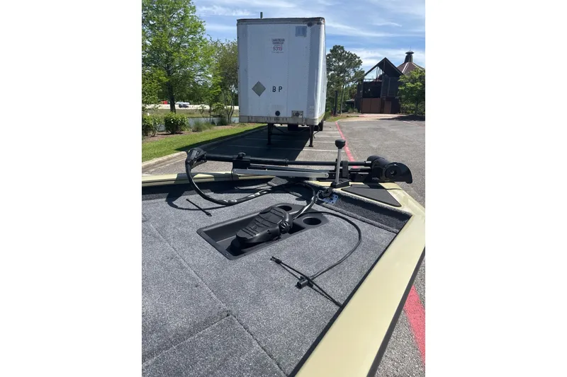 Slide: The Image of 2026 Tracker Pro Team 190 boat deck with equipment, parked near a trailer. - 7