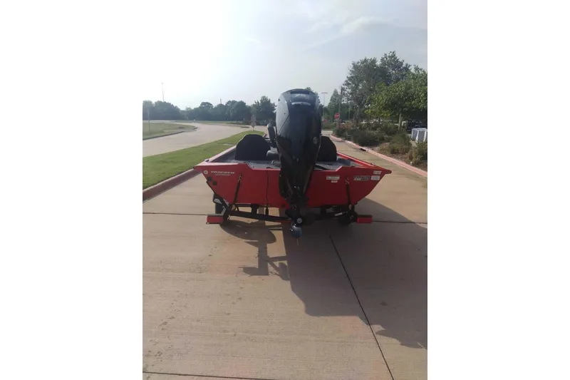 Slide: The Image of 2026 Tracker Pro Team 175 boat on a trailer, parked on a sunny road. - 9