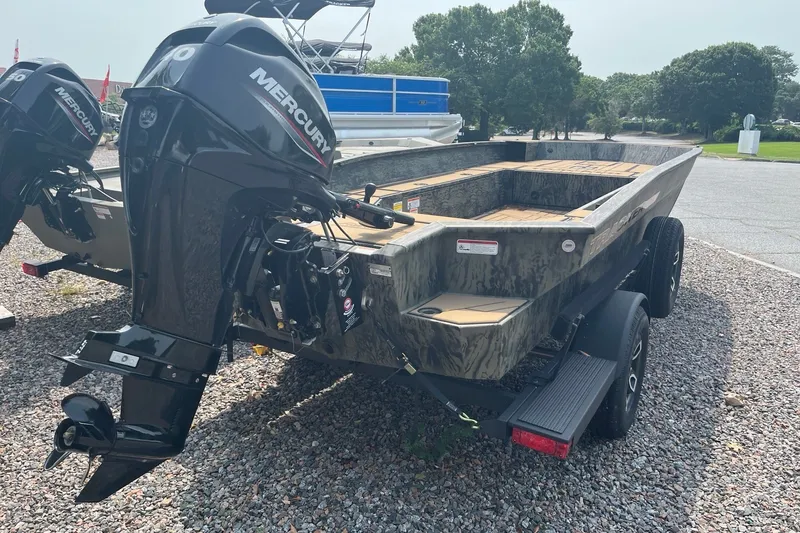 Slide: The Image of 2026 Tracker Grizzly 1756 T Marsh boat with Mercury engine on gravel lot. - 4