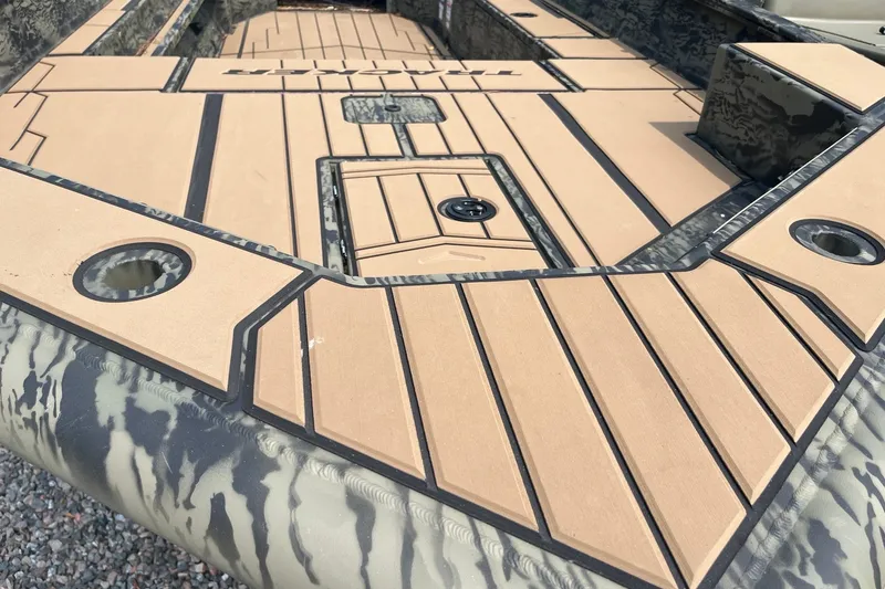 Slide: The Image of 2026 Tracker Grizzly 1756 T Marsh boat deck with camouflage design and tan flooring. - 6