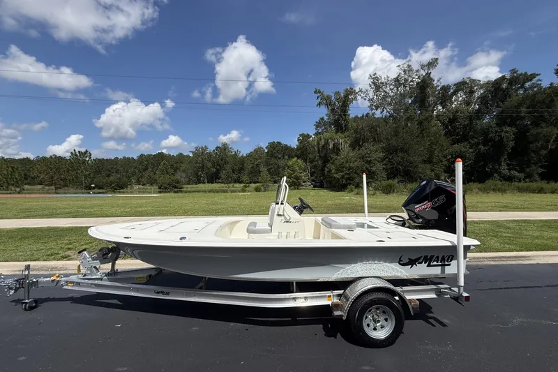The Image of 2026 Mako 18 Pro Skiff boat on trailer, parked outdoors under a clear blue sky. - 0