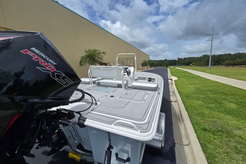 Slide: The Image of 2026 Mako 18 Pro Skiff with Mercury Pro XS engine, parked outdoors on a sunny day. - 3