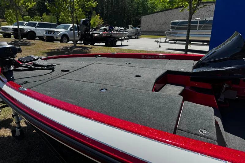 Slide: The Image of 2019 Skeeter ZX200 bass boat with red accents, parked outdoors near vehicles. - 6