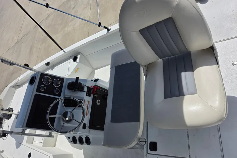 Slide: The Image of 2022 G3 Bay 18 GX boat cockpit with steering wheel and cushioned seats. - 15